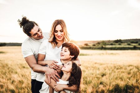 Portrait of a happy young family smiling in the countryside. Concept of family having fun in nature.の写真素材