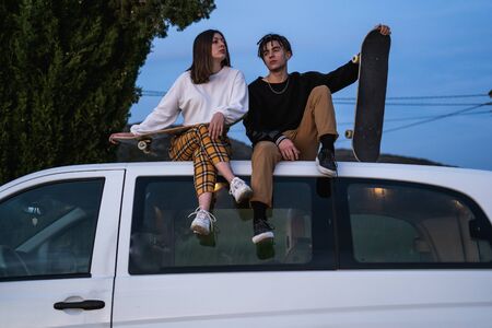 Happy young couple dressed casual in a sunset. Girl and guy kissing in love