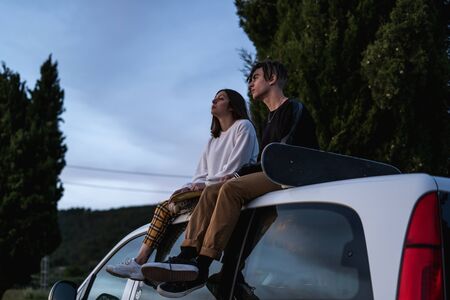 Happy young couple dressed casual in a sunset. Girl and guy kissing in love