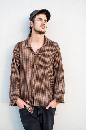 Portrait of a modern guy vintage casual dress with cap in the street. Photography style social networks. Young lifestyle conceptの写真素材