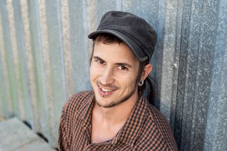 Portrait of a modern guy vintage casual dress with cap in the street. Photography style social networks. Young lifestyle conceptの写真素材
