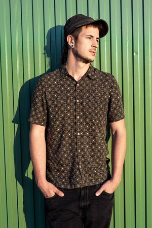 Portrait of a modern guy vintage casual dress with cap in the street. Photography style social networks. Young lifestyle conceptの写真素材