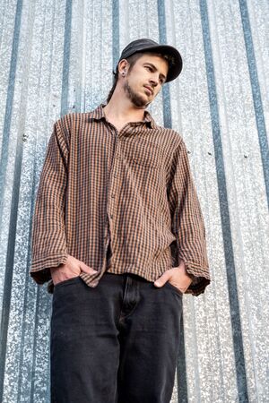 Portrait of a modern guy vintage casual dress with cap in the street. Photography style social networks. Young lifestyle conceptの写真素材