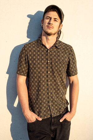 Portrait of a modern guy vintage casual dress with cap in the street. Photography style social networks. Young lifestyle conceptの写真素材