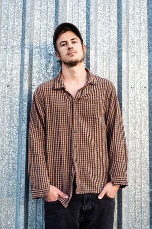 Portrait of a modern guy vintage casual dress with cap in the street. Photography style social networks. Young lifestyle conceptの写真素材