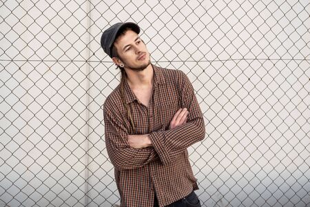 Portrait of a man in a cap dressed casually and happily. Guy looking at cameraの写真素材