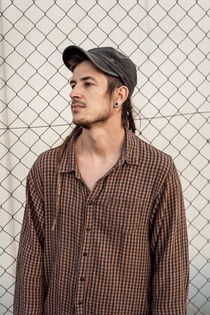 Portrait of a man in a cap dressed casually and happily. Guy looking at cameraの写真素材