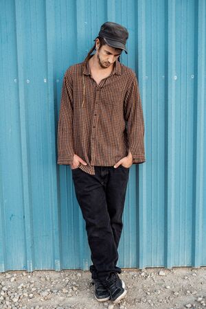 Portrait of a man in a cap dressed casually and happily. Guy looking at cameraの写真素材