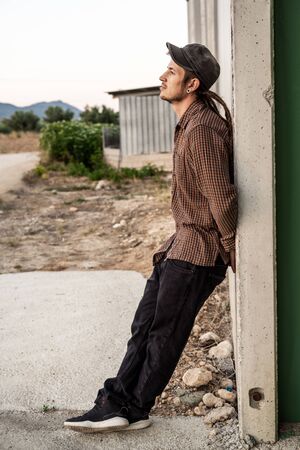 Portrait of a man in a cap dressed casually and happily. Guy looking at cameraの写真素材