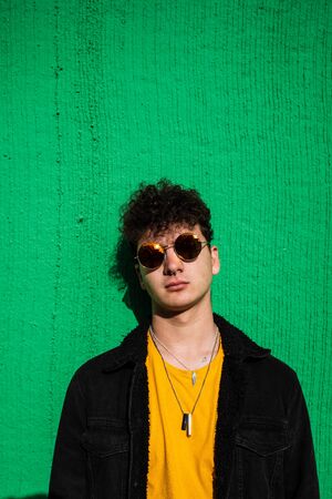 Portrait guy dressed modern in the street with sunglasses. Teenager Social Networking style photoの写真素材