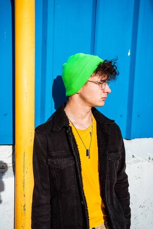 Portrait young guy in the modern city with stylish hat and blue background. Youth Lifestyle Conceptの写真素材