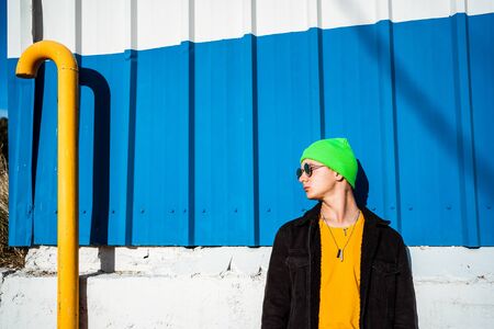 Portrait young guy in the modern city with stylish hat and blue background. Youth Lifestyle Conceptの写真素材