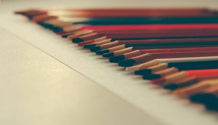 Back to school, concept from colored pencils on a yellow background from textured paper for sketching. Tinted in a trendy and modern style with a touch of noise added. Preparation for creativityの写真素材