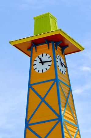 Colorful wooden clock tower against blue sky.Time concept