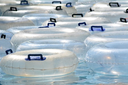 Inflatable clear inner tubes	Inflatable clear inner tubes floating in clear blue watersの写真素材