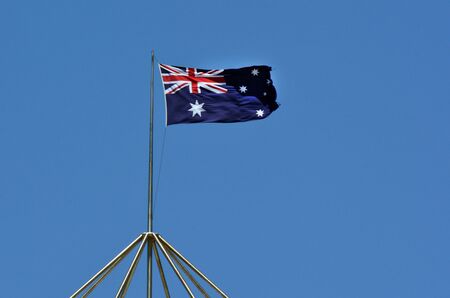 The national flag of Australia fly against blue sky.の写真素材