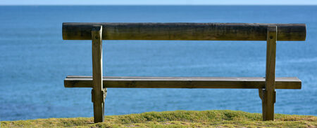 Wooden bench on open space overlooking a sea view.の写真素材