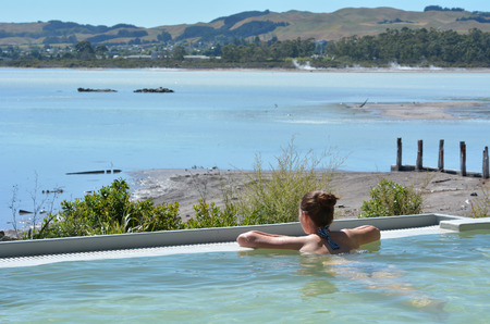 Young woman having a spa in outdoors hot pool in Rotorua, New Zealand.の写真素材