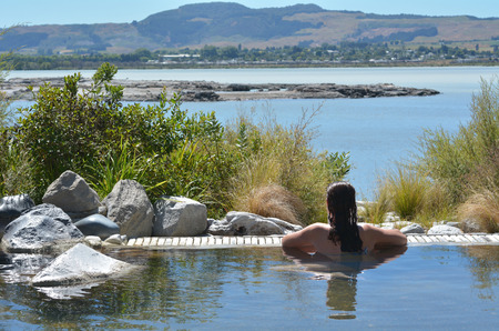 Young woman having a spa in outdoors hot pool in Rotorua, New Zealand.の写真素材