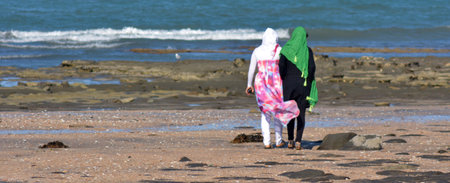 AUCKLAND, NZL - JAN 25 2015:Two muslim women on the beach.Over 130 million women and girls have experienced Female genital mutilation, 21% of Muslim girls and women have undergone FGM.のeditorial素材