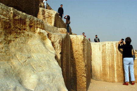 Tourists taking photos and climbing on the great pyramids in Giza, Egypt.のeditorial素材