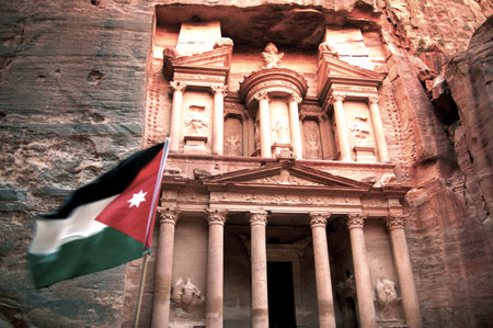 PETRA - NOV 09 2007:The Jordanian flag wav in the Treasury building at Petra.It's a symbol of Jordan, as well as its most visited tourist attraction.のeditorial素材