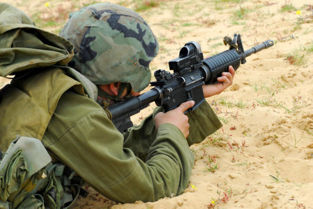 An Israeli defense forces soldier dressed in uniform aims his M16 rifle while on duty