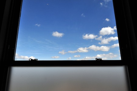 A window with a blue sky and clouds view from the Empire State Building in Manhattan, New York.