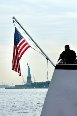 American people looks at the Statue of liberty from a boat Manhattan, New York, USA.の写真素材