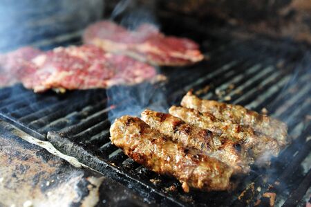Chef cooks meat on fire.