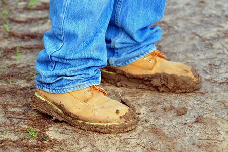 Trekking shoes coated with mud after a walking trip on a winters day.