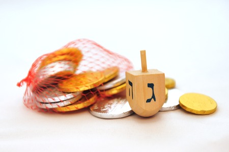 Photo of dreidels (spinning tops) and gelts (candy coins) for Hanukkah isolated on whiteの写真素材
