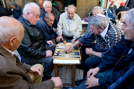 JERUSALEM - MAR 25 2015:Elderly men play backgammon in Mahane Yehuda Market in Jerusalem, Israel. Backgammon is among the oldest known board games, and many variants are played throughout the world.のeditorial素材