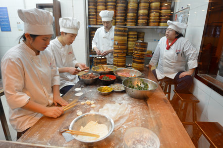 SHANGHAI, CN - MAR 17 2015:Chines chefs prepare Dim sum dumplings food at Yuyuan Tourist Mart in Shanghai, China.Dim sum dumplings it's the most popular and famous food in Shanghai, Chinaのeditorial素材