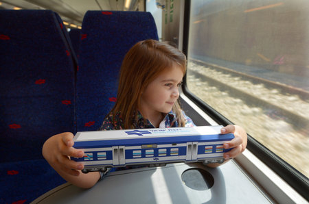 TEL AVIV - APR 05 2015:Little girl (talya Ben-Ari age 05) hold a model of Israel Railways train.It's state-owned railway company responsible for all inter-city, commuter and rail transport in Israelのeditorial素材