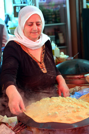 TEL AVIV, ISR - APR 06 2015:Druze woman prepare Taboon bread in the Carmel market in Tel Aviv, Israel.Taboon bread is a staple of Middle Eastern cuisine worldwide.のeditorial素材