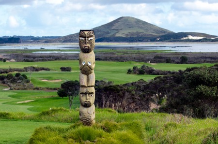 Maori carving against Rangiputa mountain in  Karikari peninsula, New Zealand.