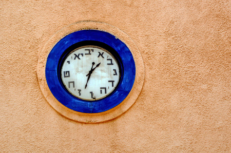 Hebrew clock on a wall of a synagogue in Israel. copyspace