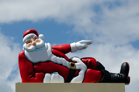 Santa Claus lying under the blue sky and white sheep clouds during Xmas and new year holidays.の写真素材