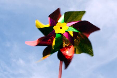 Color windmill toy move by the wind against the blue sky.