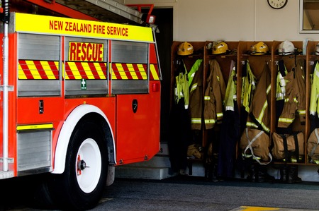 Helmets, boots and jackets in a fire station ready to be used by firefighters.の写真素材