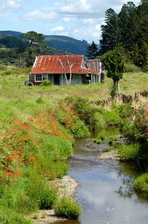 Old deserted wooden farm house near a fresh water streem in Northland New Zealand.の写真素材