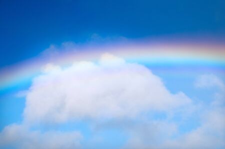 Rainbow and a white cloud in the sky.の写真素材
