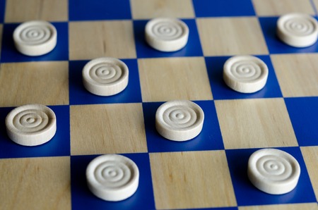 Wooden blue and white checkers game. selective focus close up. Concept photo of business, teamwork, strategy and planning.の写真素材