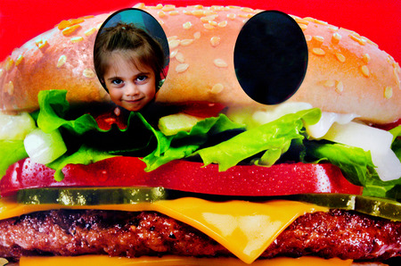 SAN FRANCISCO  - MAY 20 215.Little child Talya Ben-Ari age 05 inside a hamburger.Every day, nearly one-third of U.S. children aged 4 to 19 eat fast food, which likely increases the risk of obesity.の写真素材