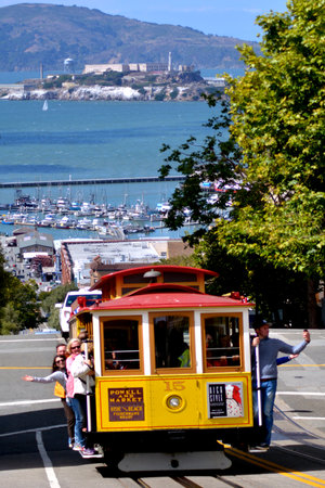 SAN FRANCISCO - MAY 20 2015:Passengers riding on Cable Car No. 15 with Alcatraz Island in the background.The current cable car network consists of three routes.のeditorial素材