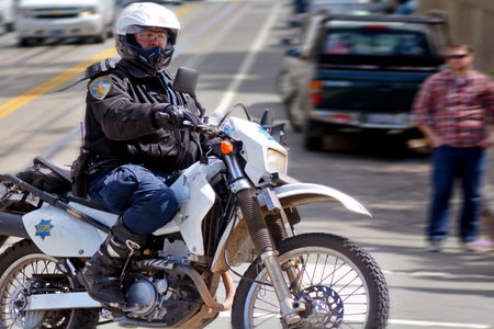 SAN FRANCISCO - MAY 20 2015:SFPD officer patrol on a motorcycle in San Francisco.The maneuverability of the motorcycle on crowded streets offer advantages over a larger traditional police vehicles.のeditorial素材