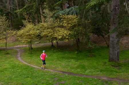 SAN FRANCISCO - MAY 19 2015:Woman runs alone in a Golden Gate park.Approximately 18%  of all rape/sexual assault incidents  take place in a public area, such as a commercial venue, parking lot or parkのeditorial素材