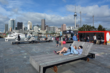 AUCKLAND - AUG 01 2015:Visitors at Wynyard Quarter against  Auckland skyline New Zealand. In 2014 Auckland has again been ranked the tenth most liveable city in the world.のeditorial素材