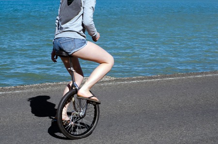 Young woman riding unicycle.の写真素材